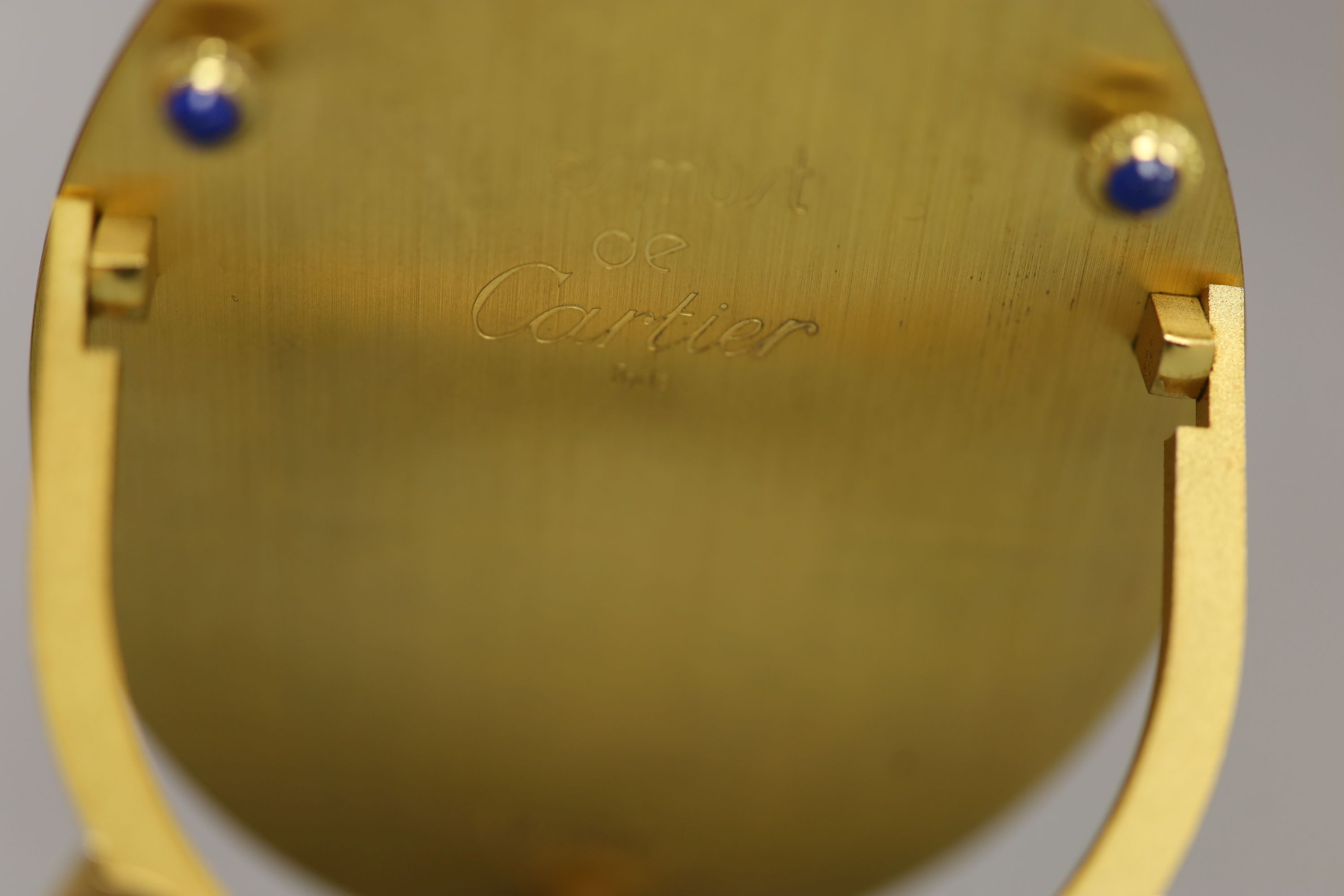 A Must de Cartier black lacquered and gilt oval easel photograph frame, length 9cm